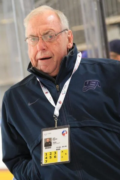 A man in a blue jacket is holding his id.