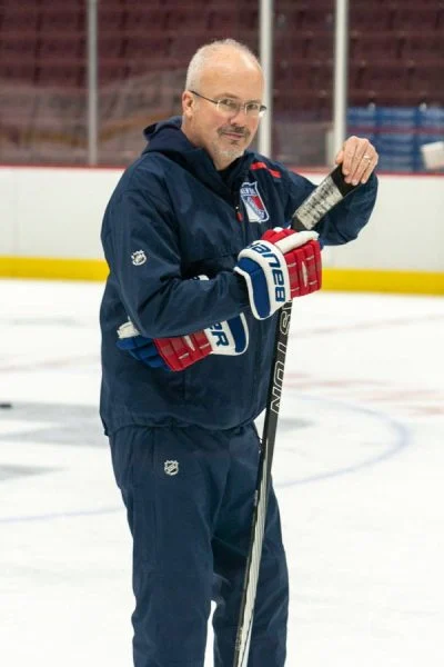 A man holding a hockey stick on the ice.
