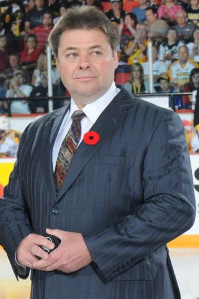 A man in a suit and tie standing next to the ice.