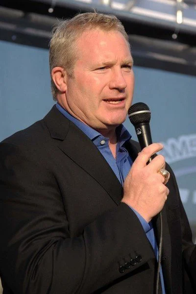 A man in a suit holding a microphone.