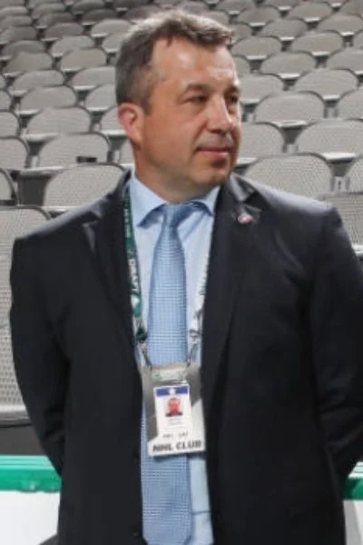 A man in suit and tie standing next to a wall.