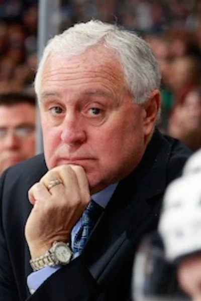 A man in suit and tie sitting at a table.
