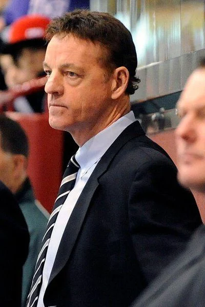 A man in suit and tie sitting next to another man.