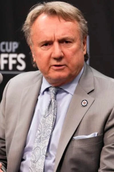 A man in a suit and tie standing next to a microphone.