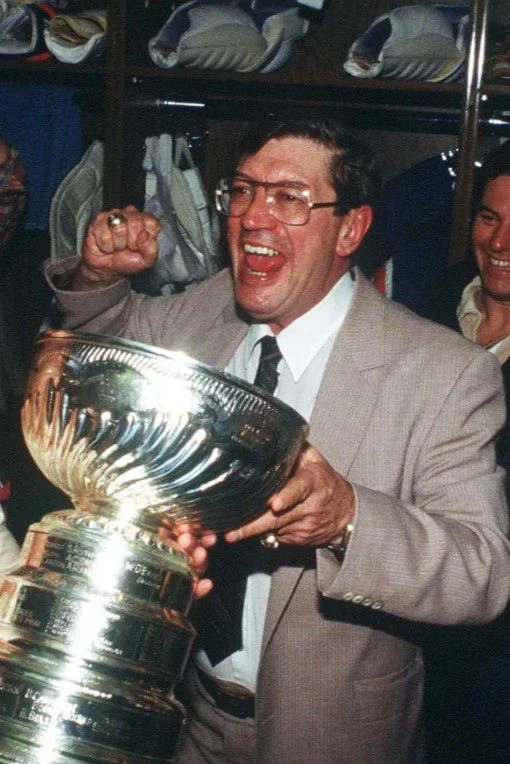A man in a suit and tie holding a trophy.