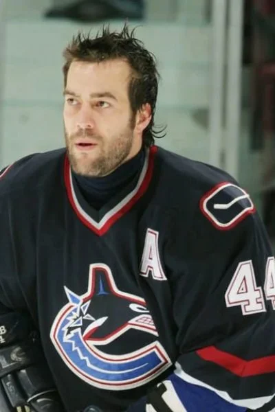 A man in black hockey uniform with a helmet on.