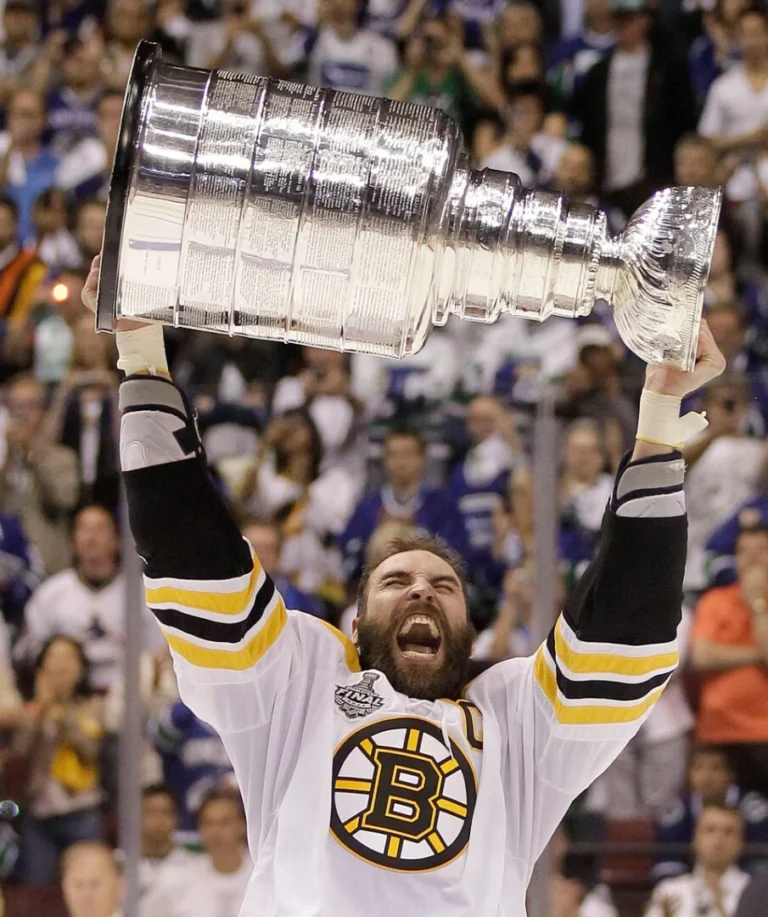 A man holding up the stanley cup in front of a crowd.