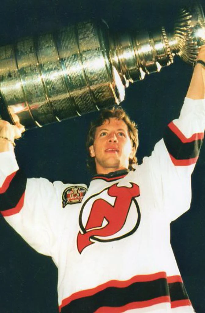 A man holding up the stanley cup in front of him.