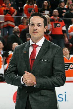 A man in a suit and tie standing on the ice.