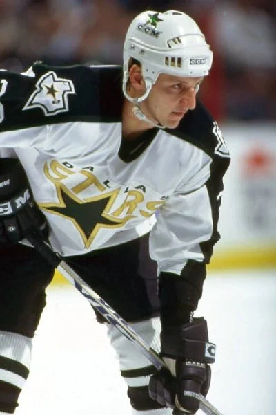 A hockey player in white and black uniform.