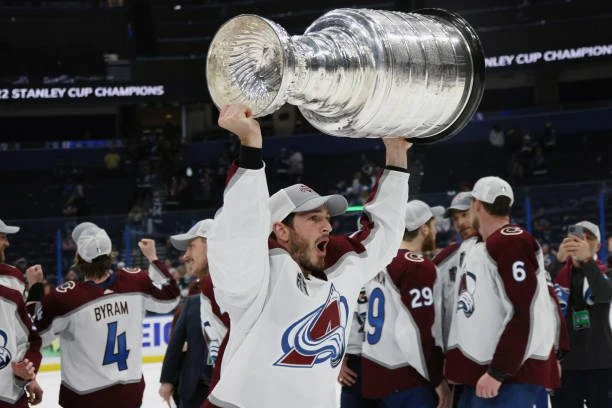 A man holding up the stanley cup in front of his face.