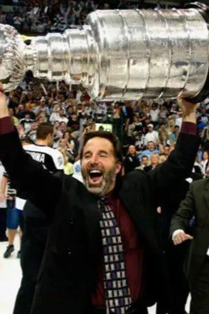 A man in a crowd of people holding up his arms.