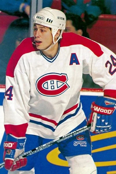 A hockey player in white and red uniform.