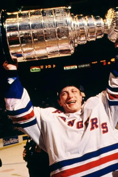 A hockey player holding up the stanley cup.