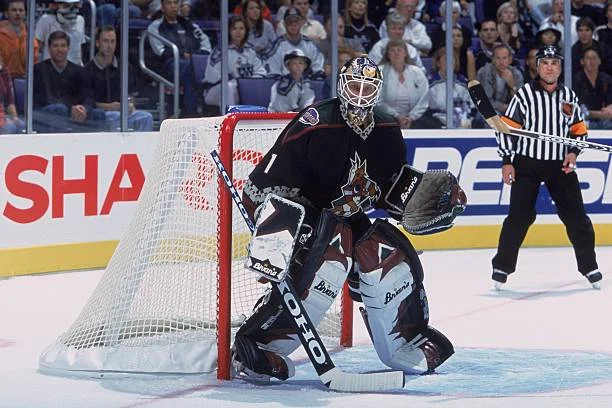 A goalie in black and white uniform on the ice.