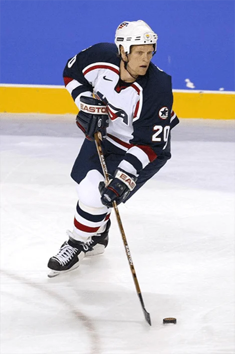 A hockey player is on the ice with his stick.
