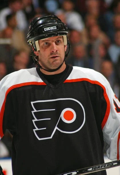 A hockey player in black and white uniform.