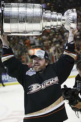 A man holding up the stanley cup in front of an audience.